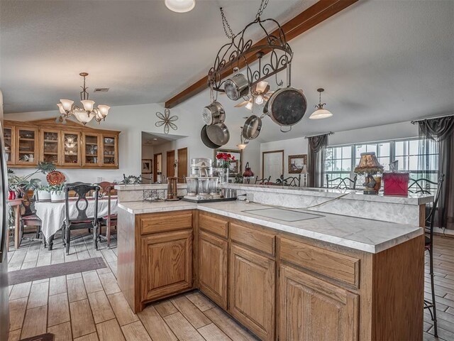 870756 S 3460th Rd, Chandler, OK 74834 - kitchen featuring a chandelier, a kitchen bar, light countertops, and brown cabinetry