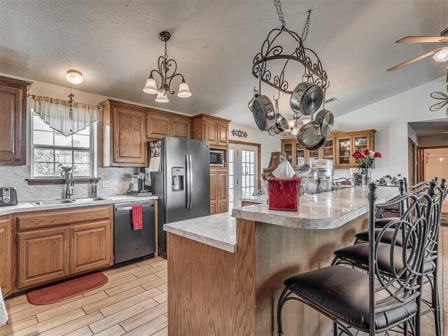 870756 S 3460th Rd, Chandler, OK 74834 - kitchen featuring appliances with stainless steel finishes, a sink, a kitchen bar, light countertops, and vaulted ceiling
