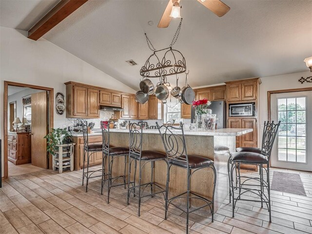 870756 S 3460th Rd, Chandler, OK 74834 - kitchen featuring stainless steel appliances, under cabinet range hood, light wood-style flooring, light countertops, and a center island