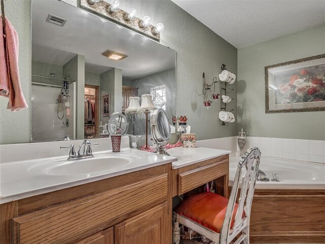 870756 S 3460th Rd, Chandler, OK 74834 - full bath featuring vanity, a textured wall, a bath, a shower stall, and a textured ceiling