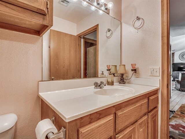 870756 S 3460th Rd, Chandler, OK 74834 - bathroom featuring vanity, a textured wall, and toilet