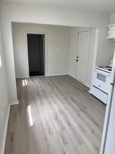3229 NE 14th Pl, Oklahoma City, OK 73117 - kitchen with white range with electric stovetop, light wood-style flooring, baseboards, and white cabinets