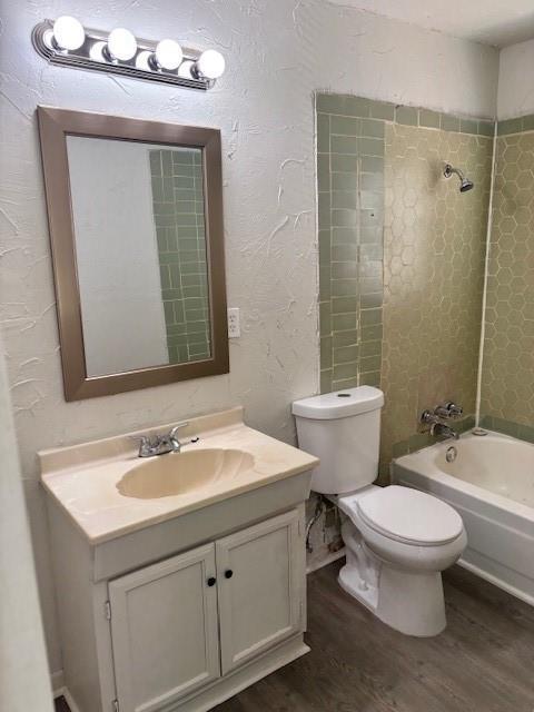 3229 NE 14th Pl, Oklahoma City, OK 73117 - full bath featuring wood finished floors, vanity, toilet, and shower / washtub combination