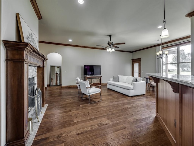 18854 Marbella Ln, Harrah, OK 73045 - living room with a fireplace with flush hearth, arched walkways, ceiling fan, dark wood finished floors, and crown molding