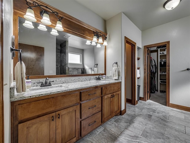 18854 Marbella Ln, Harrah, OK 73045 - full bath featuring double vanity, a walk in closet, baseboards, and stone finish flooring