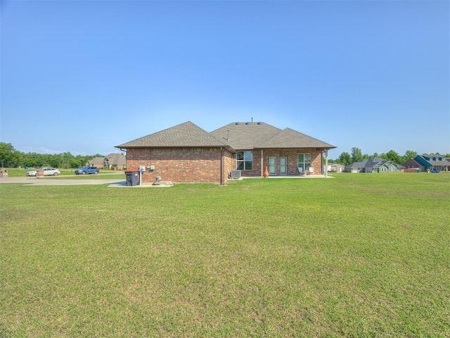 18854 Marbella Ln, Harrah, OK 73045 - back of house with a lawn, brick siding, and a shingled roof
