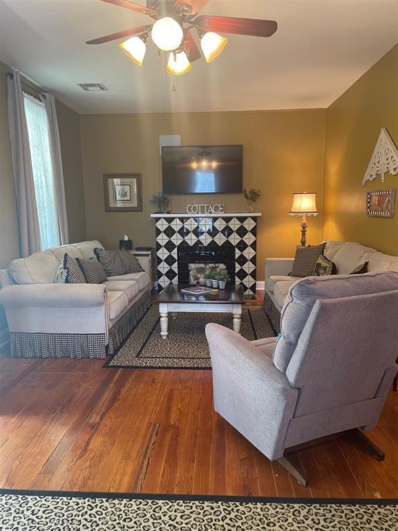 819 S Macomb Ave, El Reno, OK 73036 - living area featuring hardwood / wood-style flooring, ceiling fan, and a fireplace