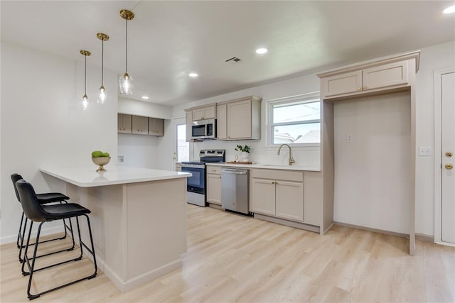 1309 NW 106th St, Oklahoma City, OK 73114 - kitchen with stainless steel appliances, a sink, a breakfast bar area, healthy amount of natural light, and recessed lighting