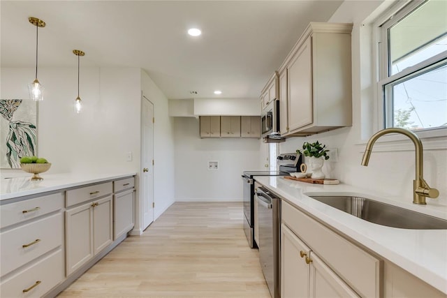 1309 NW 106th St, Oklahoma City, OK 73114 - kitchen featuring a sink, appliances with stainless steel finishes, light wood-style flooring, pendant lighting, and recessed lighting
