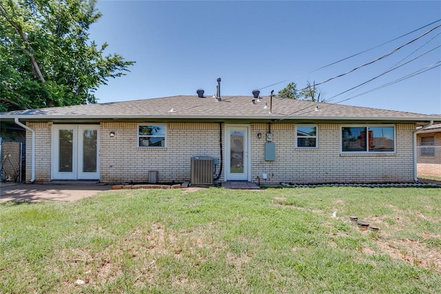 1309 NW 106th St, Oklahoma City, OK 73114 - back of house featuring brick siding, central AC, and a yard