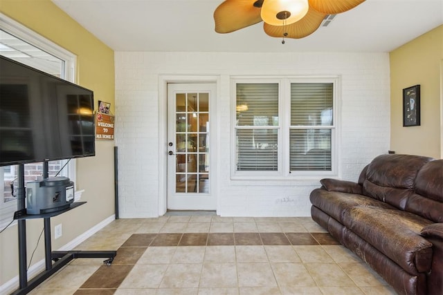 605 S Timber Ridge Dr, Cushing, OK 74023 - tiled living room with brick wall and a ceiling fan