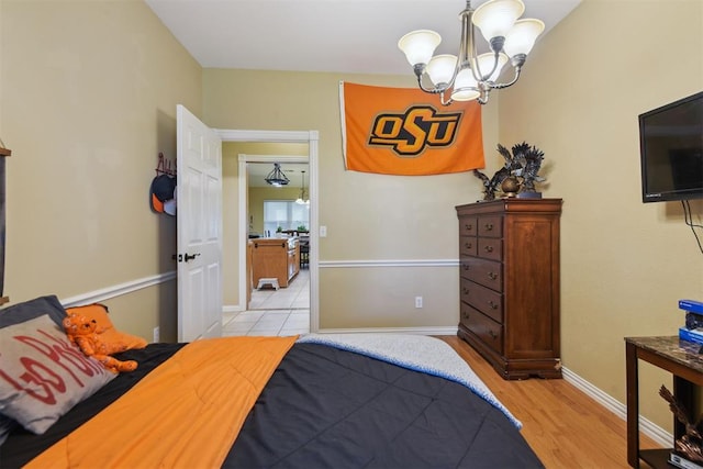 605 S Timber Ridge Dr, Cushing, OK 74023 - bedroom featuring a chandelier, light wood-style flooring, and baseboards