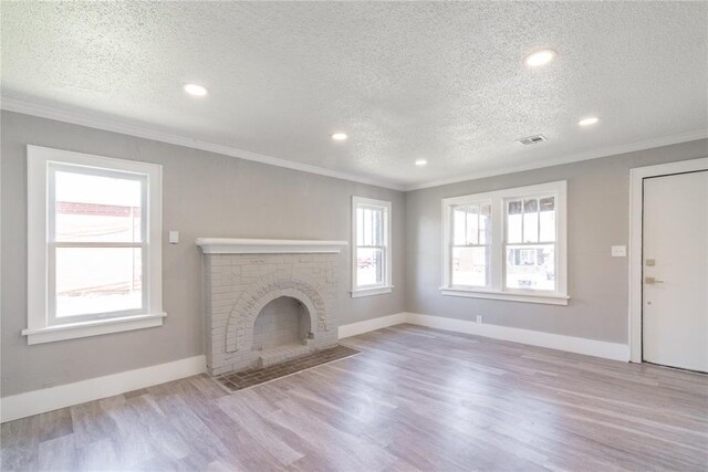 2301 N Kelham Ave, Oklahoma City, OK 73111 - unfurnished living room with crown molding, a textured ceiling, wood finished floors, baseboards, and a brick fireplace