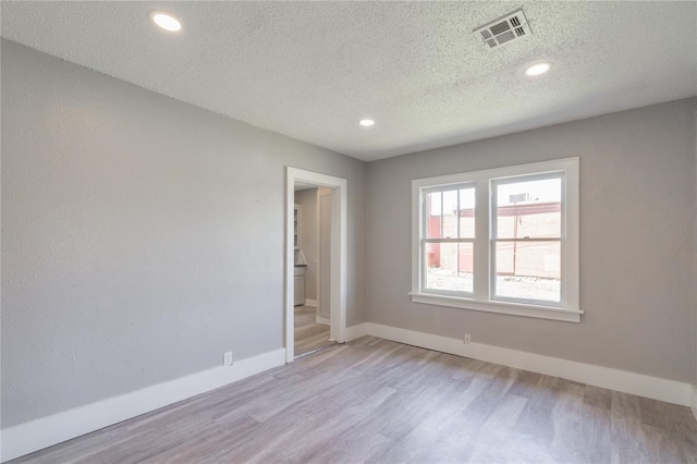 2301 N Kelham Ave, Oklahoma City, OK 73111 - empty room featuring a textured ceiling, light wood-style flooring, baseboards, and recessed lighting