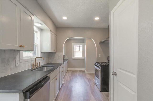 2301 N Kelham Ave, Oklahoma City, OK 73111 - kitchen featuring stainless steel appliances, a sink, decorative backsplash, a textured ceiling, and baseboards