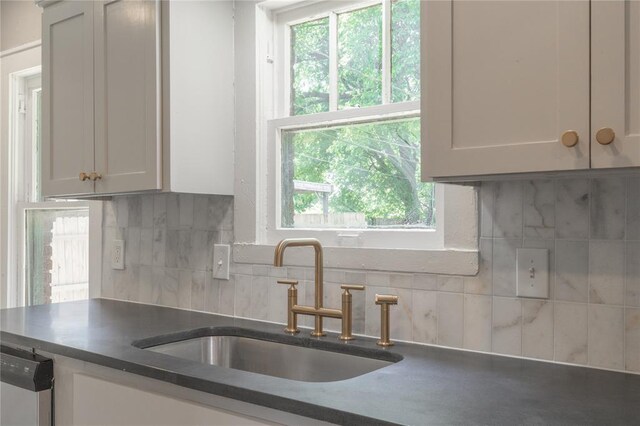 2301 N Kelham Ave, Oklahoma City, OK 73111 - kitchen with a sink, decorative backsplash, dark countertops, and stainless steel dishwasher
