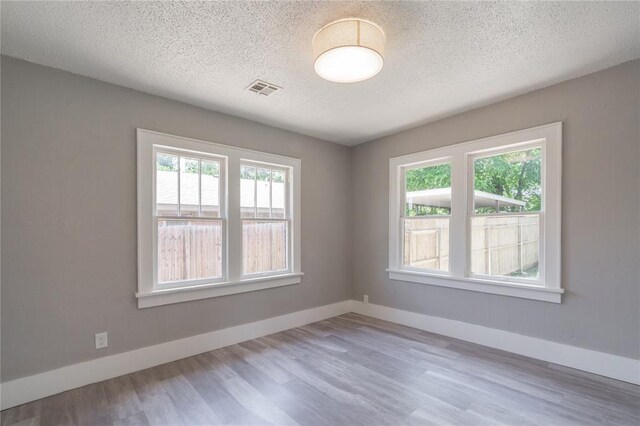2301 N Kelham Ave, Oklahoma City, OK 73111 - unfurnished room featuring wood finished floors, a textured ceiling, and baseboards