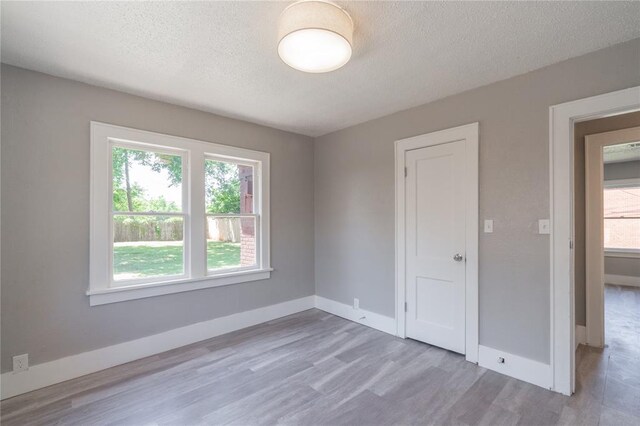 2301 N Kelham Ave, Oklahoma City, OK 73111 - spare room featuring wood finished floors, a textured ceiling, and baseboards