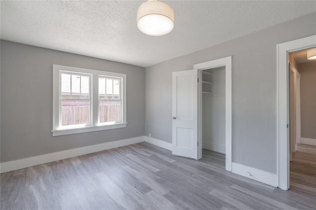 2301 N Kelham Ave, Oklahoma City, OK 73111 - unfurnished bedroom featuring a textured ceiling, wood finished floors, a closet, and baseboards