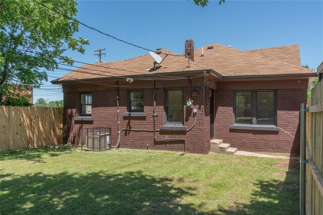 2301 N Kelham Ave, Oklahoma City, OK 73111 - rear view of house with brick siding, central AC, and a shingled roof