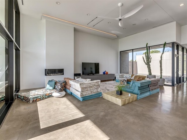 11300 N Westminster Rd, Jones, OK 73049 - living room featuring finished concrete flooring, a ceiling fan, a high ceiling, and recessed lighting