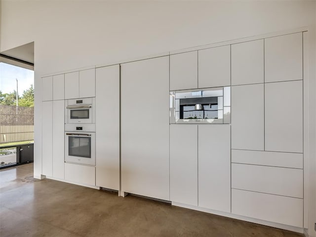 11300 N Westminster Rd, Jones, OK 73049 - kitchen with white double oven, white cabinets, finished concrete floors, and modern cabinets