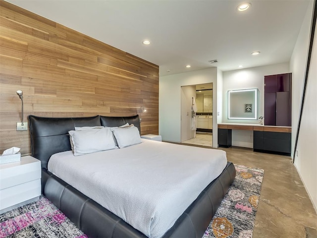 11300 N Westminster Rd, Jones, OK 73049 - bedroom featuring wood walls, finished concrete flooring, recessed lighting, ensuite bathroom, and baseboards