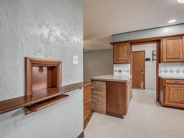 513 SW 57th St, Oklahoma City, OK 73109 - kitchen with tasteful backsplash, brown cabinets, light floors, light countertops, and recessed lighting
