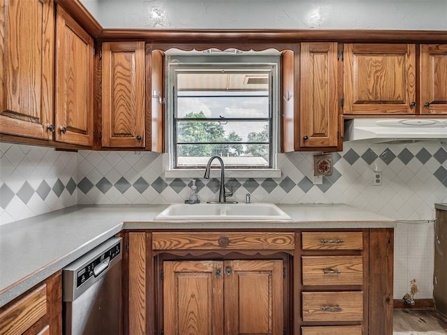 513 SW 57th St, Oklahoma City, OK 73109 - kitchen with a sink, dishwasher, brown cabinets, under cabinet range hood, and light countertops
