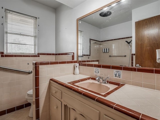 513 SW 57th St, Oklahoma City, OK 73109 - bathroom with a tile shower, toilet, vanity, and tile walls