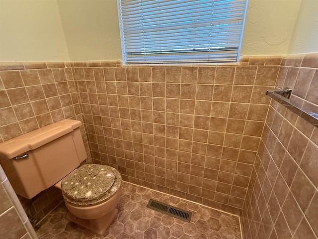 1908 NW 56th Ter, Oklahoma City, OK 73118 - bathroom with tile walls, toilet, and a wainscoted wall