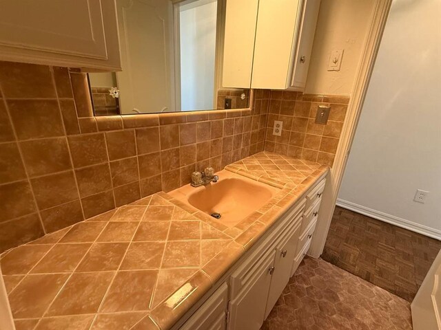 1908 NW 56th Ter, Oklahoma City, OK 73118 - bathroom featuring vanity, decorative backsplash, and baseboards