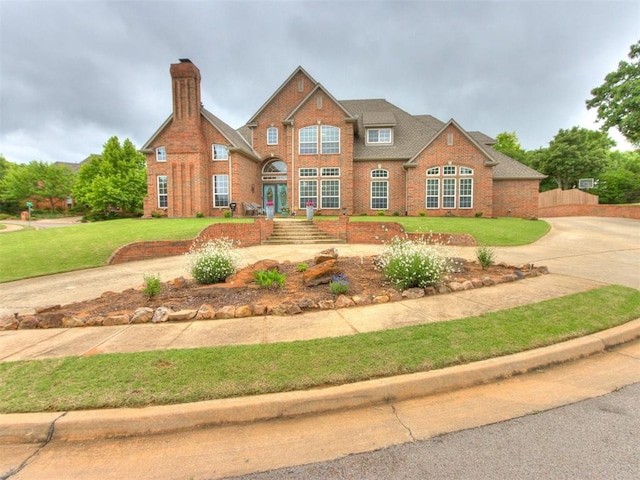 2508 Thunderwind Cir, Edmond, OK 73034 - traditional-style home featuring brick siding, a front yard, a chimney, and concrete driveway