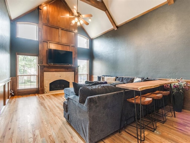 2508 Thunderwind Cir, Edmond, OK 73034 - living room featuring high vaulted ceiling, a ceiling fan, wood finished floors, a fireplace, and beamed ceiling