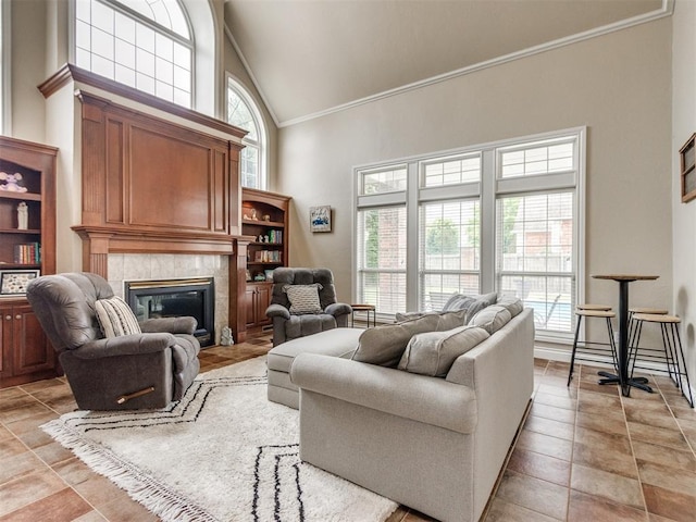 2508 Thunderwind Cir, Edmond, OK 73034 - living area with ornamental molding, high vaulted ceiling, a premium fireplace, and light tile patterned floors