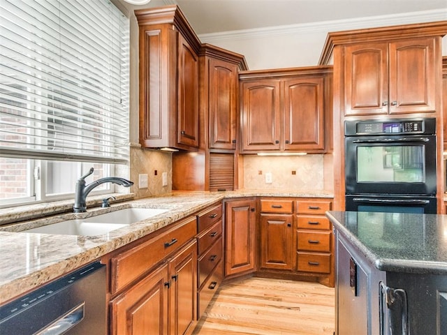 2508 Thunderwind Cir, Edmond, OK 73034 - kitchen with stainless steel dishwasher, a sink, light wood-style floors, crown molding, and light stone countertops