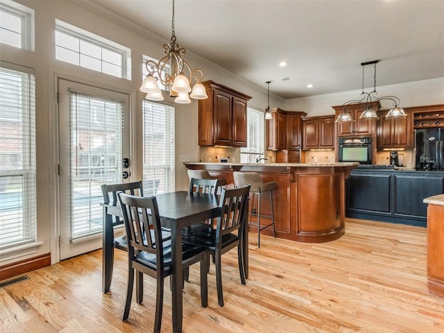 2508 Thunderwind Cir, Edmond, OK 73034 - dining space featuring ornamental molding, plenty of natural light, light wood finished floors, a chandelier, and recessed lighting