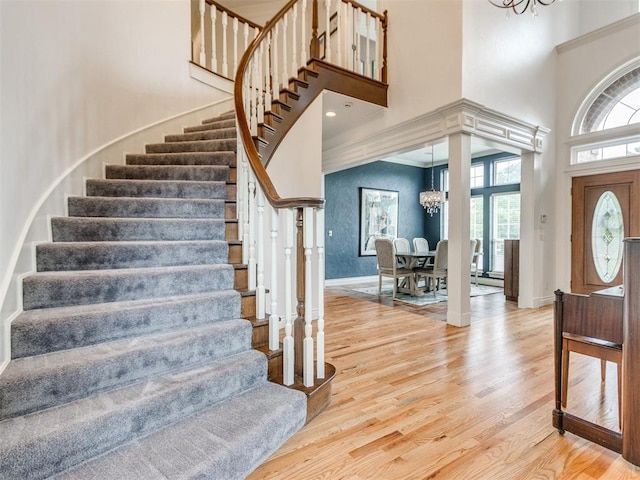 2508 Thunderwind Cir, Edmond, OK 73034 - foyer with a chandelier, a high ceiling, stairway, light wood-type flooring, and baseboards