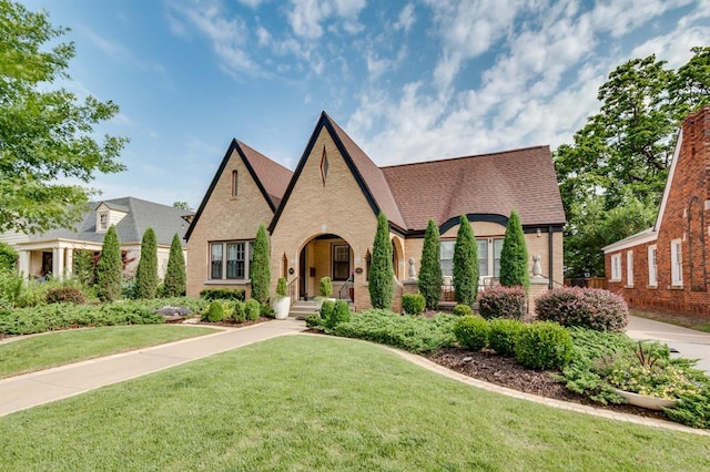 915 NW 40th St, Oklahoma City, OK 73118 - tudor house featuring brick siding, a front yard, and a shingled roof