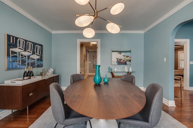915 NW 40th St, Oklahoma City, OK 73118 - dining space with arched walkways, ornamental molding, dark wood-type flooring, baseboards, and a chandelier