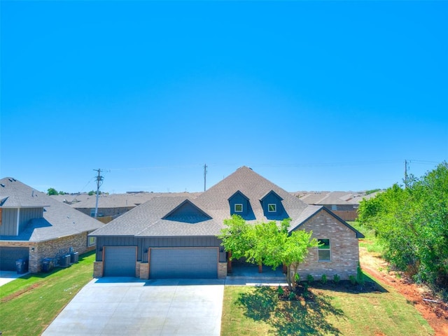 11508 NW 102nd St, Yukon, OK 73099 - view of front of home with an attached garage, roof with shingles, driveway, and a front yard