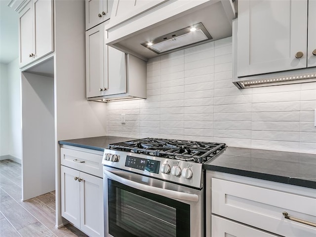 11508 NW 102nd St, Yukon, OK 73099 - kitchen with stainless steel range with gas stovetop, custom exhaust hood, light wood-type flooring, and backsplash