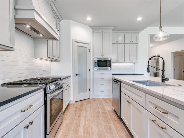 11508 NW 102nd St, Yukon, OK 73099 - kitchen with appliances with stainless steel finishes, custom range hood, a sink, light stone countertops, and decorative backsplash