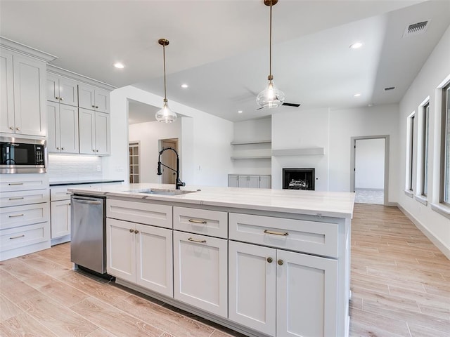 11508 NW 102nd St, Yukon, OK 73099 - kitchen with a sink, appliances with stainless steel finishes, light wood-style floors, ceiling fan, and recessed lighting