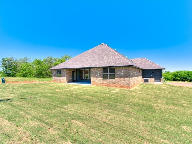 11508 NW 102nd St, Yukon, OK 73099 - back of property featuring a yard, roof with shingles, a patio, and brick siding