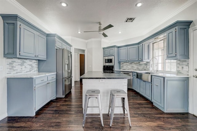 10904 Quail Run Rd, Oklahoma City, OK 73150 - kitchen with stainless steel appliances, a ceiling fan, a center island, a sink, and tasteful backsplash