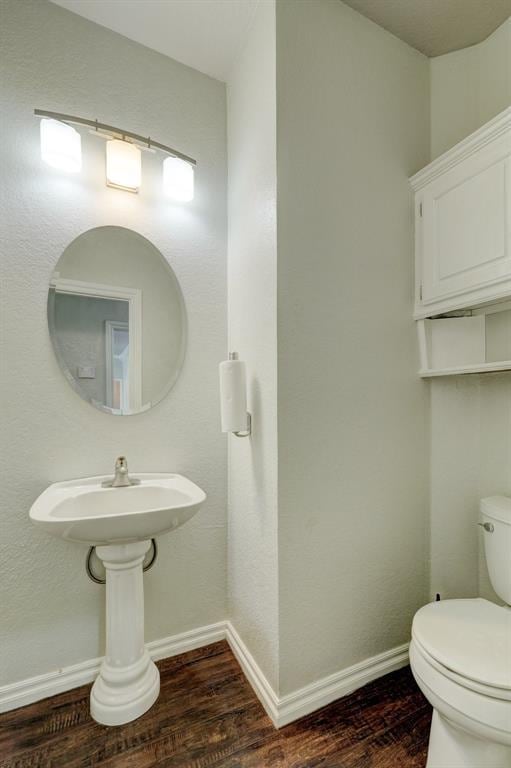10904 Quail Run Rd, Oklahoma City, OK 73150 - half bath featuring wood finished floors, toilet, and baseboards