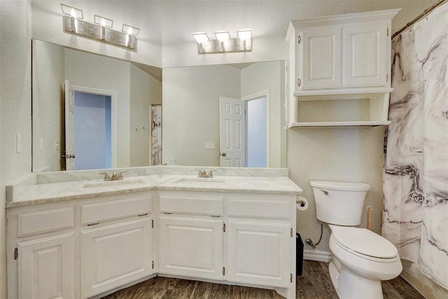 10904 Quail Run Rd, Oklahoma City, OK 73150 - bathroom with double vanity, toilet, wood finished floors, and a shower with curtain