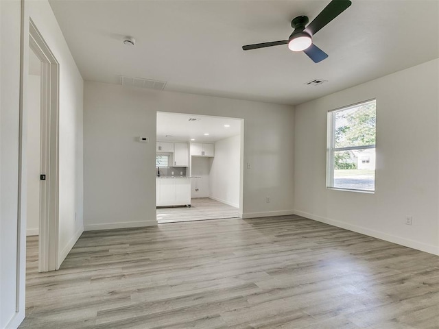 920 N Warren Ave, Oklahoma City, OK 73107 - unfurnished living room with ceiling fan, baseboards, and light wood-type flooring