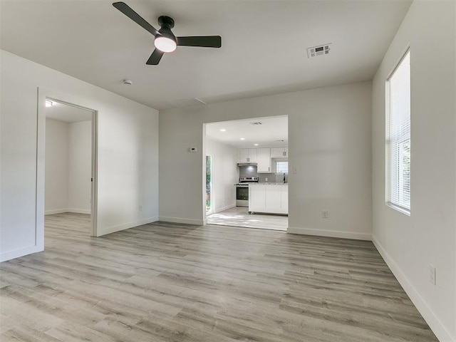 920 N Warren Ave, Oklahoma City, OK 73107 - unfurnished living room featuring a ceiling fan, light wood-style floors, baseboards, and recessed lighting